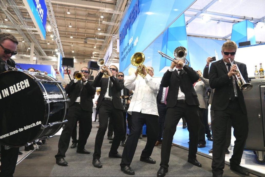 standparty-walking-act-walkact-stand-party-messe-marching-band-messestand-party-hamburg-messeparty–1030×689